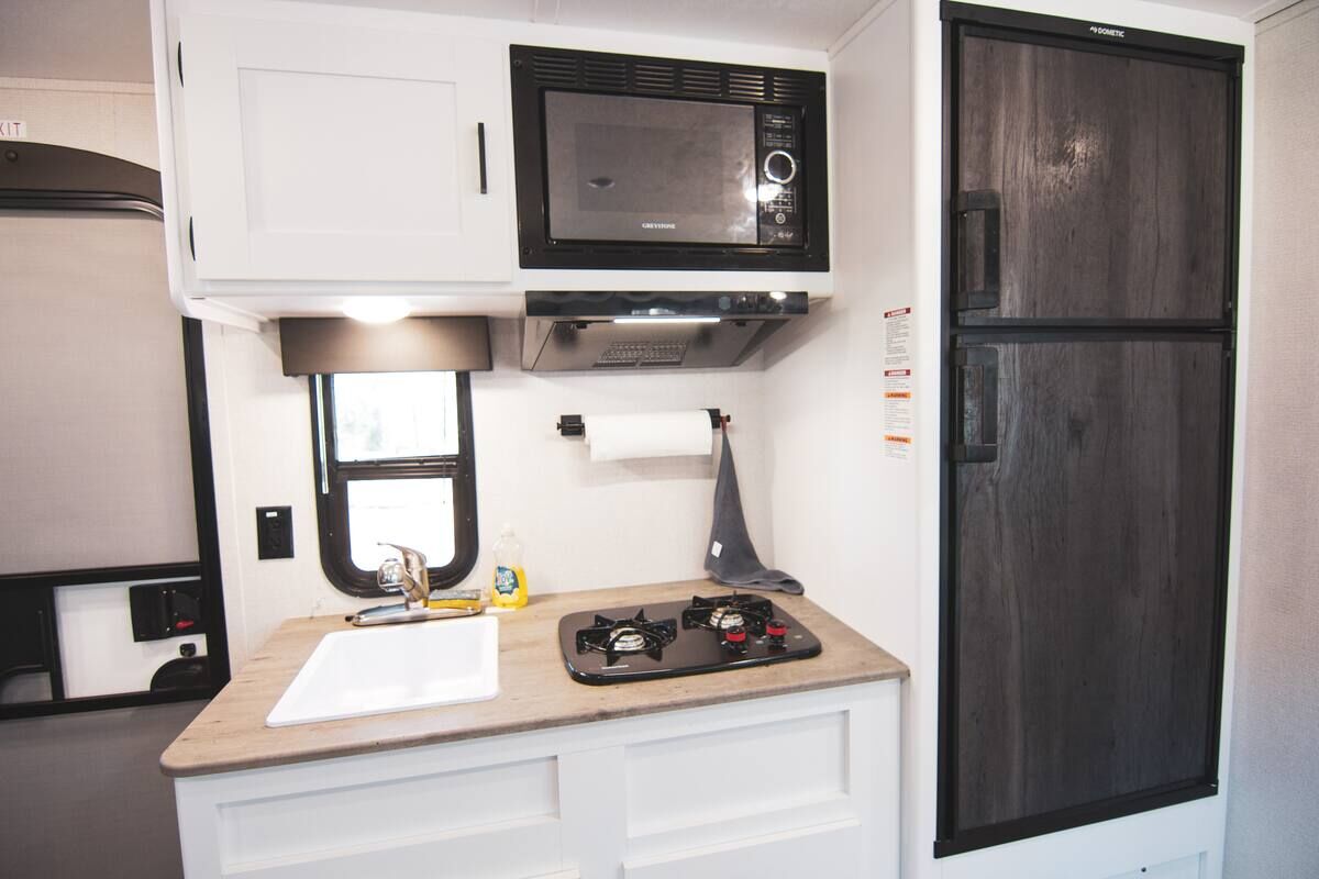 Kitchenette with a microwave, gas cooktop and refrigerator