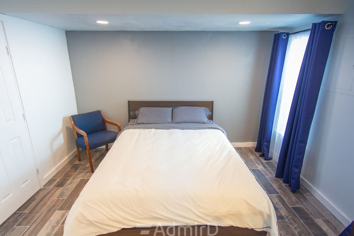 Bedroom with a queen bed and an accent chair