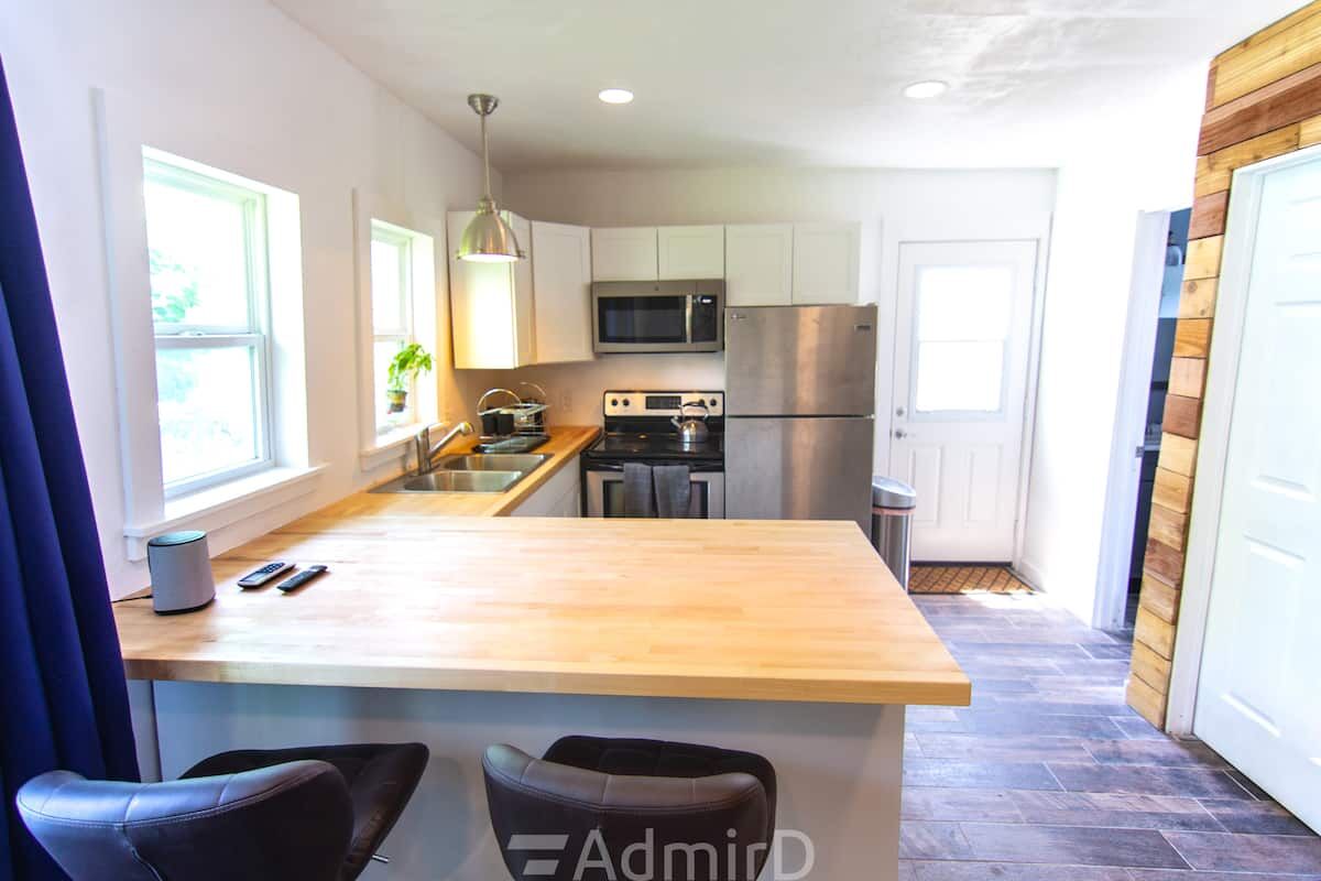 Remodeled kitchen with butcher-block counters, white cabinets and a stainless refrigerator in the Corpus Christi guest house