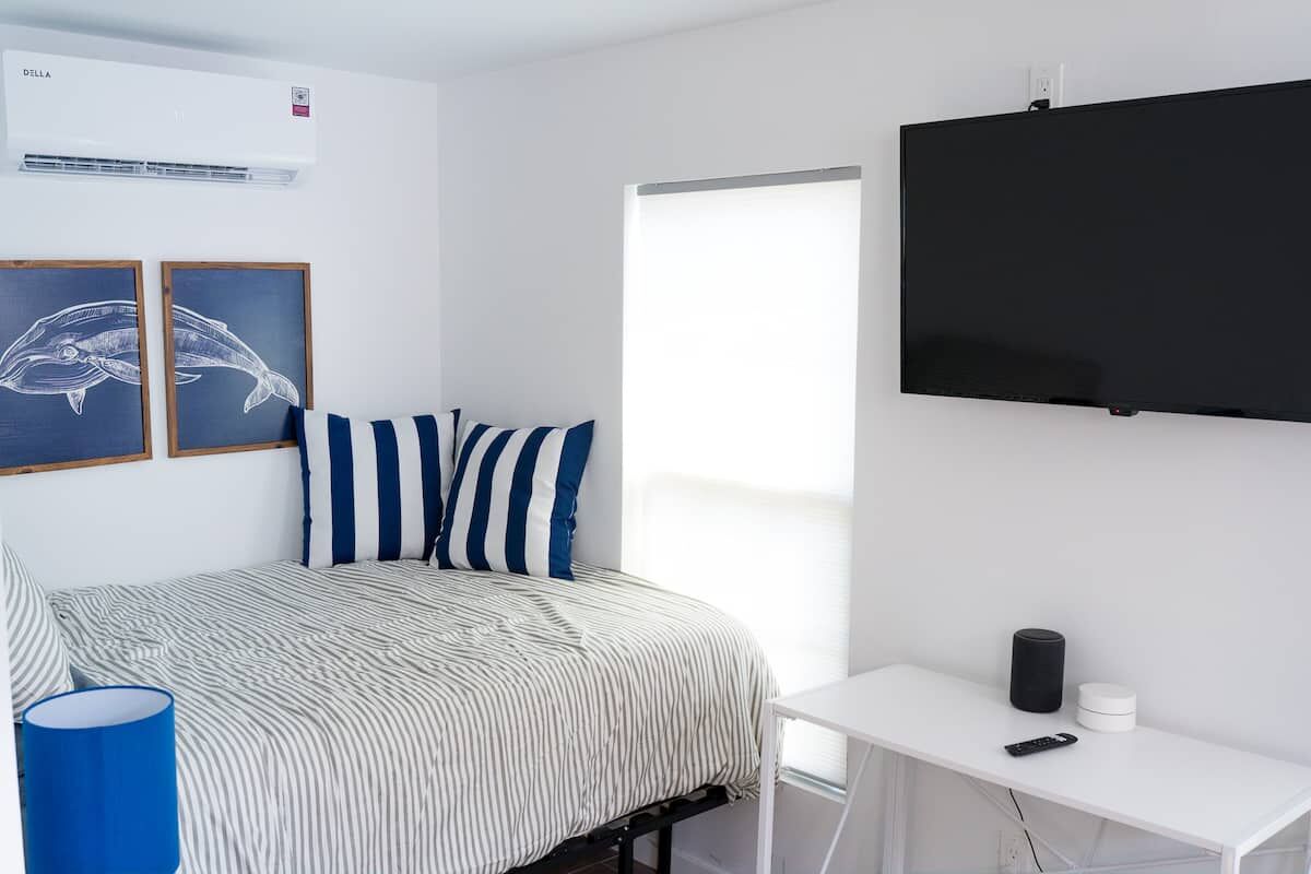 Bed and a wall-mounted TV in the studio
