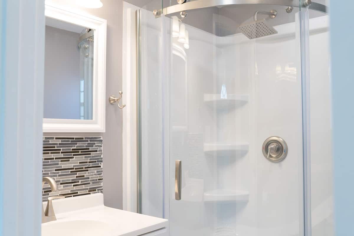 Glass corner shower with built-in shelves