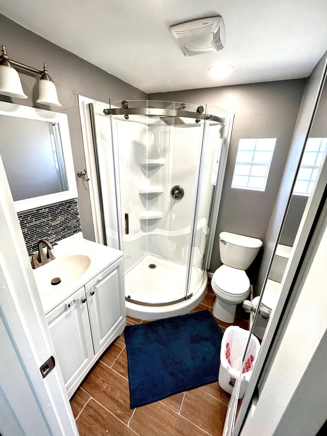 Corner shower with a glass door and a vanity