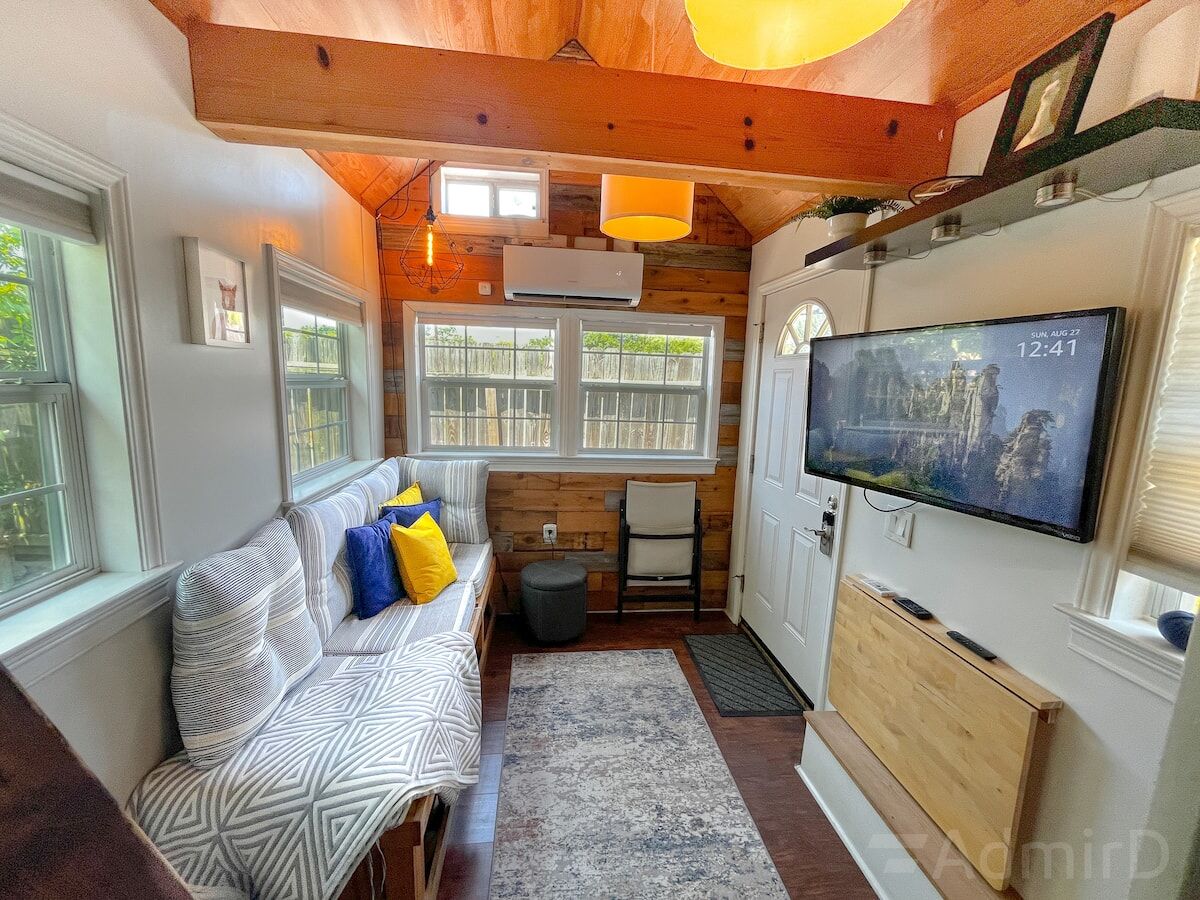 Houston Tiny House interior with a wall-mounted TV and bench seating