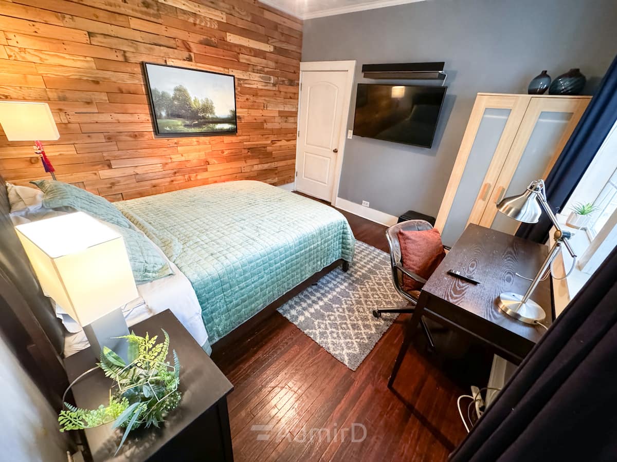 Bedroom with a desk, wardrobe and wall-mounted TV near Downtown Houston