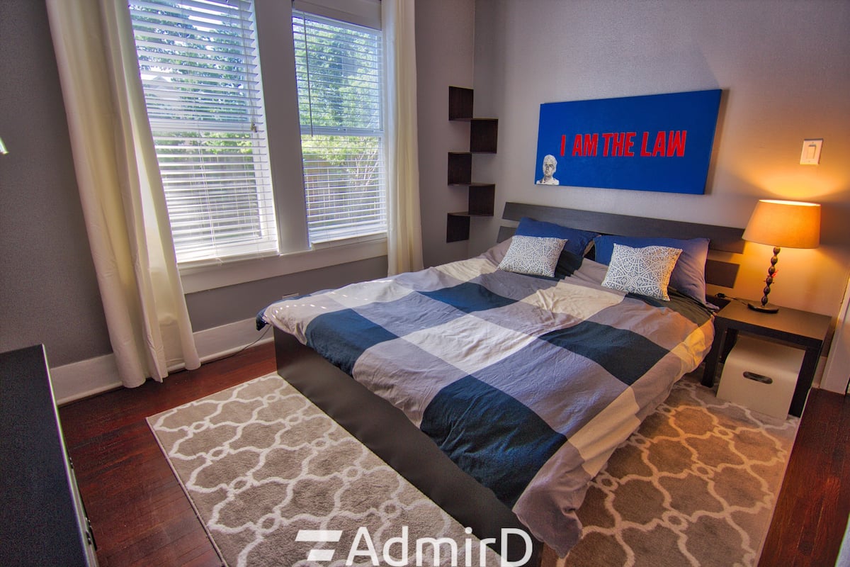 Furnished private room with a plaid bed, lamp and bright windows in Midtown Houston