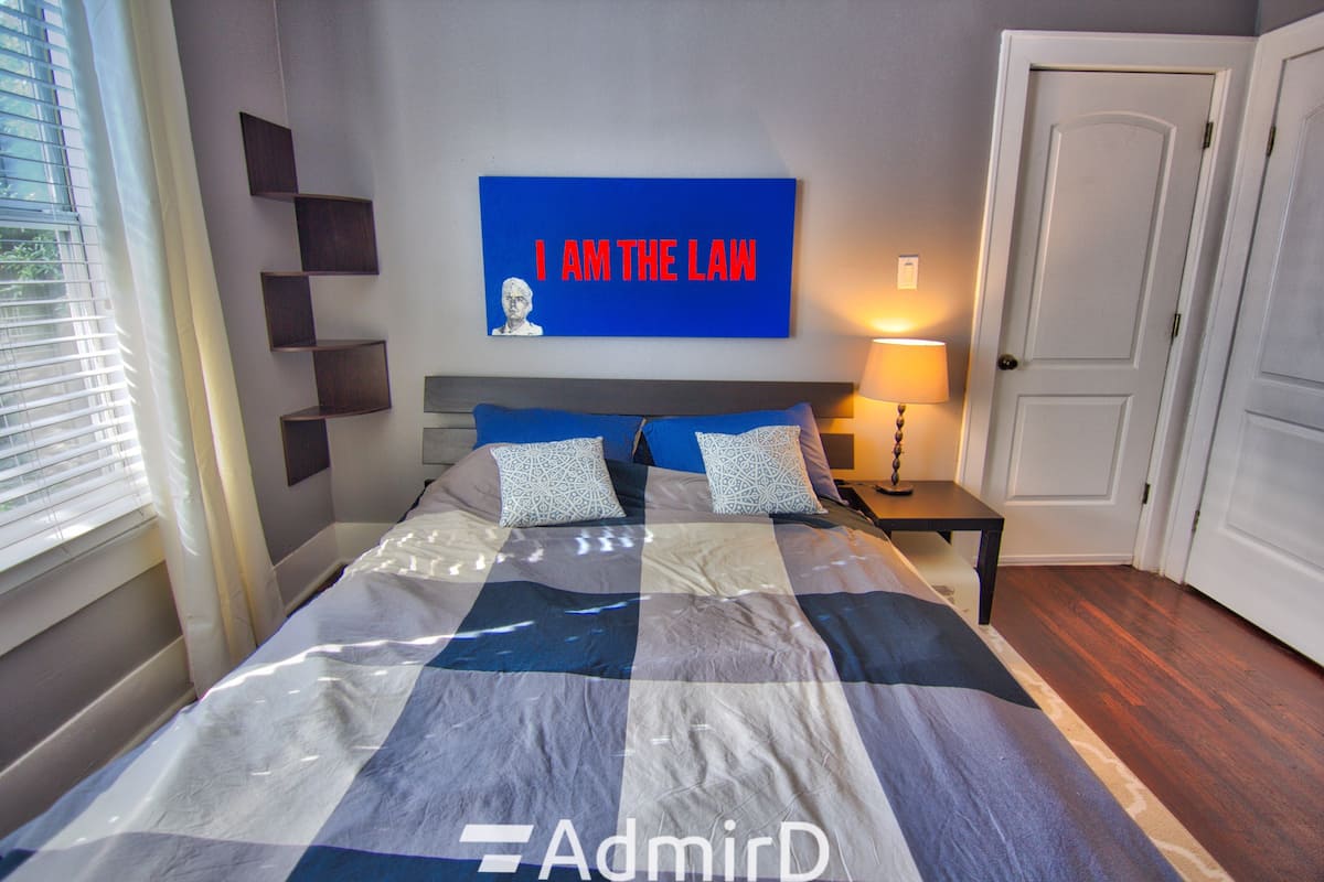 Bedroom with a plaid bedspread, bedside table and wall art