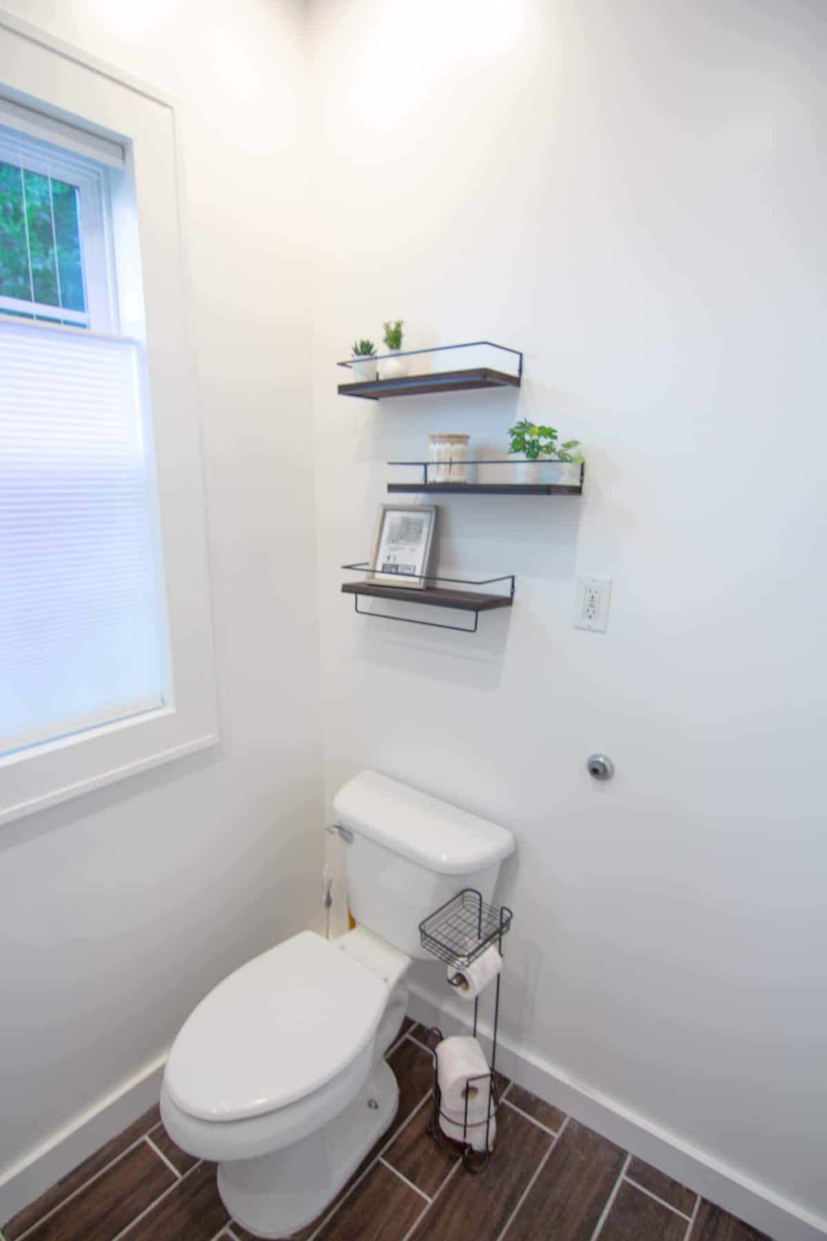Shared bathroom with floating shelves and a window