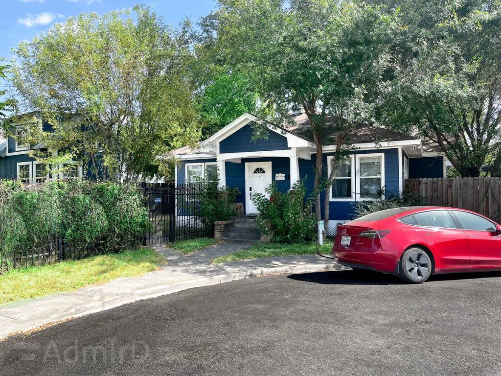 Blue bungalow in Houston Midtown with a front porch and a gate